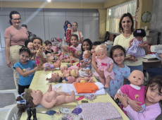 As meninas se encantaram com as novas vestimentas das bonecas do Lar Maria de Nazaré