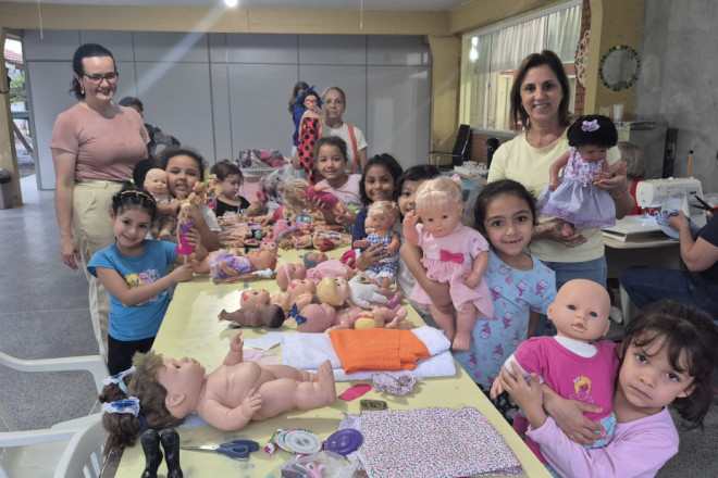 As meninas se encantaram com as novas vestimentas das bonecas do Lar Maria de Nazaré