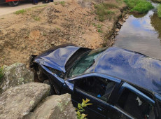 Ve&iacute;culo tombou em um riacho na margem da estrada