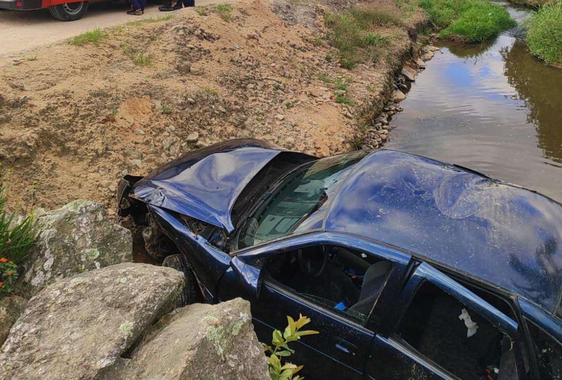 Veículo tombou em um riacho na margem da estrada