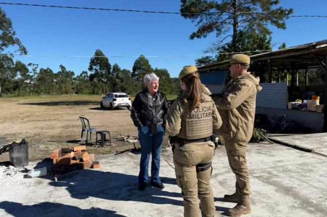 A secret&aacute;ria Neuza conversa com Policiais Militares que acompanharam a abordagem e prenderam o foragido da Justi&ccedil;a