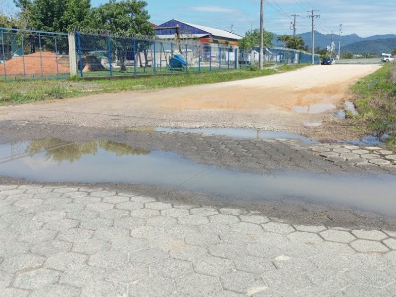 Buraco e ac&uacute;mulo de &aacute;gua em via da cidade
